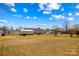 Expansive backyard featuring large metal outbuilding, several storage buildings, and mature trees at 655 Mock Mill Rd, Statesville, NC 28677