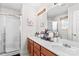 Bright bathroom with double sink vanity, large mirror, and shower with glass doors at 655 Mock Mill Rd, Statesville, NC 28677