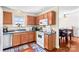 Well-lit kitchen features wood cabinets, white appliances, and view to dining area at 655 Mock Mill Rd, Statesville, NC 28677