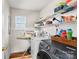 Bright laundry room has new front loading washer and dryer, and overhead wire shelves at 655 Mock Mill Rd, Statesville, NC 28677