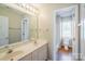Bathroom with double sinks, bright lighting, a mirror and an adjoining room at 6916 Sardis Green Ct, Charlotte, NC 28270