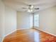 Cozy bedroom with hardwood floors, a ceiling fan, and a large window at 6916 Sardis Green Ct, Charlotte, NC 28270
