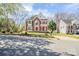 Charming brick two-story home featuring bright red shutters and front door and well-manicured lawn at 6916 Sardis Green Ct, Charlotte, NC 28270
