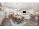 Inviting dining area with a rustic table, modern lighting, and an open flow to the living space at 7056 Cornwallis Ct, Iron Station, NC 28080