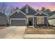 Charming home exterior with a manicured front lawn, two-car garage, and inviting front entrance with a wreath at 7056 Cornwallis Ct, Iron Station, NC 28080