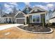 Well-manicured lawn featuring a gray single Gathering home with white trim, a garage, and easy driveway access at 7056 Cornwallis Ct, Iron Station, NC 28080