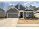 Charming single Gathering home featuring gray siding, well-kept landscaping, and an attached two-car garage at 7056 Cornwallis Ct, Iron Station, NC 28080