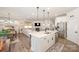 Open-concept kitchen and living area with a spacious island, stainless steel appliances, and comfortable seating at 7056 Cornwallis Ct, Iron Station, NC 28080