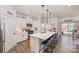 Bright, modern kitchen with white cabinets, stainless steel appliances, a large island, and bar stool seating at 7056 Cornwallis Ct, Iron Station, NC 28080