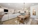 Open-concept living and dining area with wood floors, a fireplace, and modern decor for entertaining at 7056 Cornwallis Ct, Iron Station, NC 28080