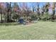 Level backyard featuring playset, trampoline, swings and mature trees at 737 Waverly Pl, Statesville, NC 28677