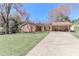 Charming brick ranch home with a long driveway and covered carport nestled on a lush, green lawn at 737 Waverly Pl, Statesville, NC 28677