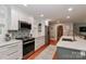 Bright kitchen boasts stainless appliances, quartz countertops, white cabinetry, and island with barstool seating at 737 Waverly Pl, Statesville, NC 28677