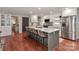 Bright kitchen boasts stainless appliances, quartz countertops, white cabinetry, and island with barstool seating at 737 Waverly Pl, Statesville, NC 28677