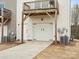 Exterior view of garage with white door and wooden support beams for second story deck at 8260 Waxhaw Hwy, Waxhaw, NC 28173