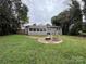 Expansive backyard features a cozy brick fire pit and a well-maintained lawn at 842 E Woodlawn Rd, Charlotte, NC 28209