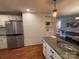 Bright kitchen with stainless steel refrigerator, granite countertops, and white brick wall at 842 E Woodlawn Rd, Charlotte, NC 28209