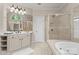 Bright bathroom with a walk-in shower, a tub, a large mirror and a vanity with under cabinet storage at 1119 Lytton Ln, Matthews, NC 28104