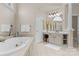 Bright bathroom with a tub, a large mirror, a vanity with cabinets, shelves and drawers at 1119 Lytton Ln, Matthews, NC 28104