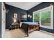 This navy bedroom features a window with natural light, and a wooden bed frame at 1119 Lytton Ln, Matthews, NC 28104
