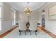 Elegant dining room featuring wainscoting, hardwood floors, and a stylish chandelier at 1119 Lytton Ln, Matthews, NC 28104
