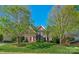 Traditional red brick home featuring manicured landscaping, symmetrical design, and a welcoming entrance at 1119 Lytton Ln, Matthews, NC 28104