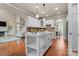 Bright, modern kitchen open to living room, with white cabinets, island, and hardwood floors at 1119 Lytton Ln, Matthews, NC 28104