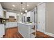 Bright kitchen features white cabinetry, stainless steel appliances, granite counters and hardwood floors at 1119 Lytton Ln, Matthews, NC 28104
