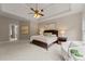 Main bedroom suite with tray ceilings, carpet, ceiling fan, and ensuite bathroom at 1119 Lytton Ln, Matthews, NC 28104