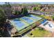 Aerial shot of community tennis courts and pool facilities with lush surrounding trees and blue shade structures at 1119 Lytton Ln, Matthews, NC 28104