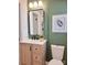 Updated bathroom features a new vanity, fixtures, and green accent wall at 112 Greentree Dr, Mount Holly, NC 28120