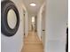 Hallway with wood flooring, a decorative mirror, and access to multiple rooms, showing the home's layout at 112 Greentree Dr, Mount Holly, NC 28120