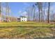 Expansive backyard with lush green grass, framed by mature trees and a clear blue sky at 126 Orville Rd, Statesville, NC 28677