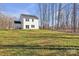 Two-story home with white siding is surrounded by a lush green yard and tall trees at 126 Orville Rd, Statesville, NC 28677