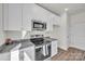 Modern kitchen featuring white cabinets, granite countertops, and stainless steel appliances at 126 Orville Rd, Statesville, NC 28677