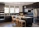 Stylish kitchen featuring dark cabinets, stainless steel appliances, an island with seating, and modern lighting at 1518 Levy Way, Charlotte, NC 28205