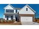 Charming two-story home featuring a brick facade, white siding, black shutters, and a two-car garage at 1829 Augustine St, Monroe, NC 28112