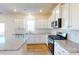 Modern kitchen with granite countertops, stainless steel appliances, white cabinetry, and hardwood flooring at 1829 Augustine St, Monroe, NC 28112