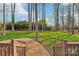 Lush backyard with mature trees, split rail fence, and gravel path leading to the lawn at 1916 Dugan Dr, Charlotte, NC 28270