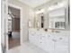 A well-lit bathroom features a double vanity, white cabinets, and a doorway to the main bedroom at 1916 Dugan Dr, Charlotte, NC 28270