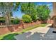 An inviting backyard with a brick retaining wall, mature landscaping, and concrete patio for entertaining guests at 1963 Wexford Ct, Gastonia, NC 28054