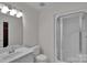 Bathroom featuring a white vanity, sink, glass enclosed shower and ample mirror illuminated by modern lighting at 1963 Wexford Ct, Gastonia, NC 28054