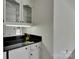 Wet bar with sleek black countertop, mirrored backsplash and glass front cabinets at 1963 Wexford Ct, Gastonia, NC 28054
