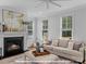 Inviting living room with a fireplace, neutral decor and large windows for natural light at 19728-A School St, Cornelius, NC 28031