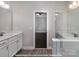 This bathroom features a double vanity with white cabinets and modern fixtures with wood-look flooring at 19732-B School St, Cornelius, NC 28031