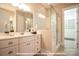 This bathroom features a modern vanity with drawers, a glass-enclosed shower, and an adjacent walk-in closet at 19732-B School St, Cornelius, NC 28031