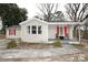 Quaint home with neutral vinyl siding, bright red shutters and a cozy, covered front porch at 2010 Simmons St, Gaston, NC 28052