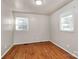 This bedroom features gleaming hardwood floors and bright natural light from dual windows at 213 Turner Rd, Gastonia, NC 28056