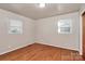 This bedroom features gleaming hardwood floors and bright natural light from dual windows at 213 Turner Rd, Gastonia, NC 28056