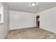 A simple bedroom with neutral carpet leads to a view of the rest of the home at 213 Turner Rd, Gastonia, NC 28056